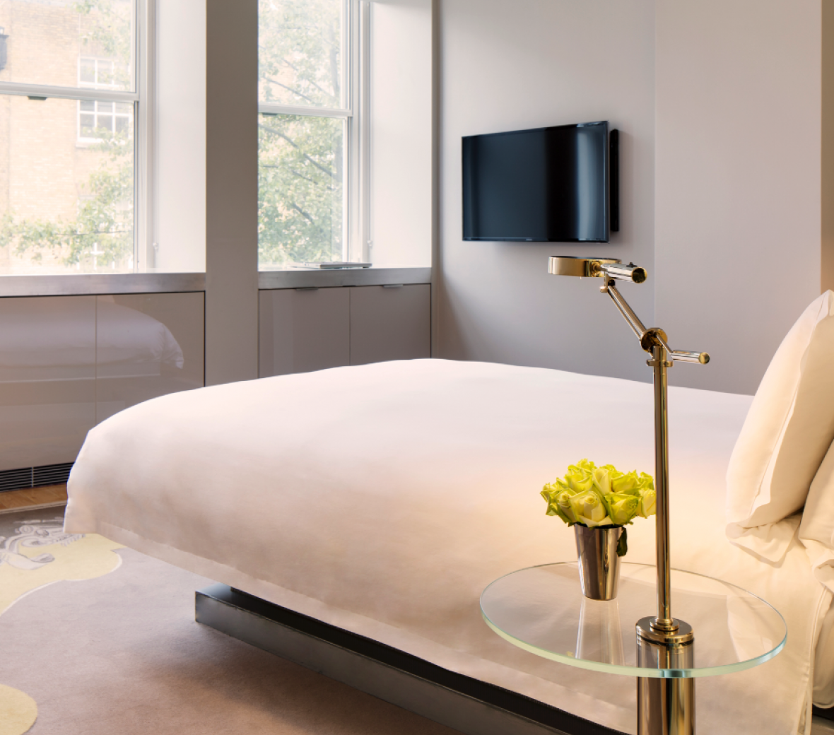 hotel bed wit white linens and tv on the wall