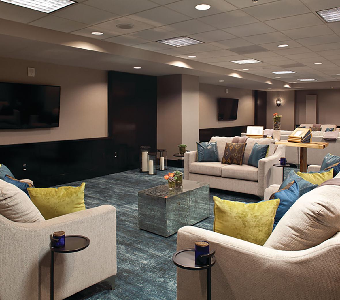 A comfortable media room with multiple sofas and screens
