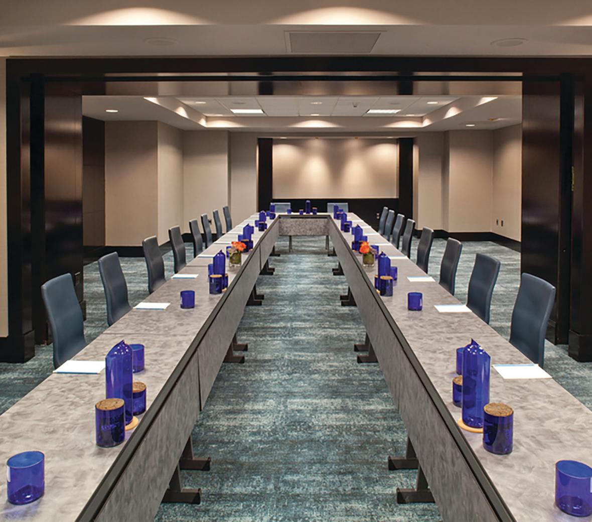 Meeting room set up with two rows of tables and chairs