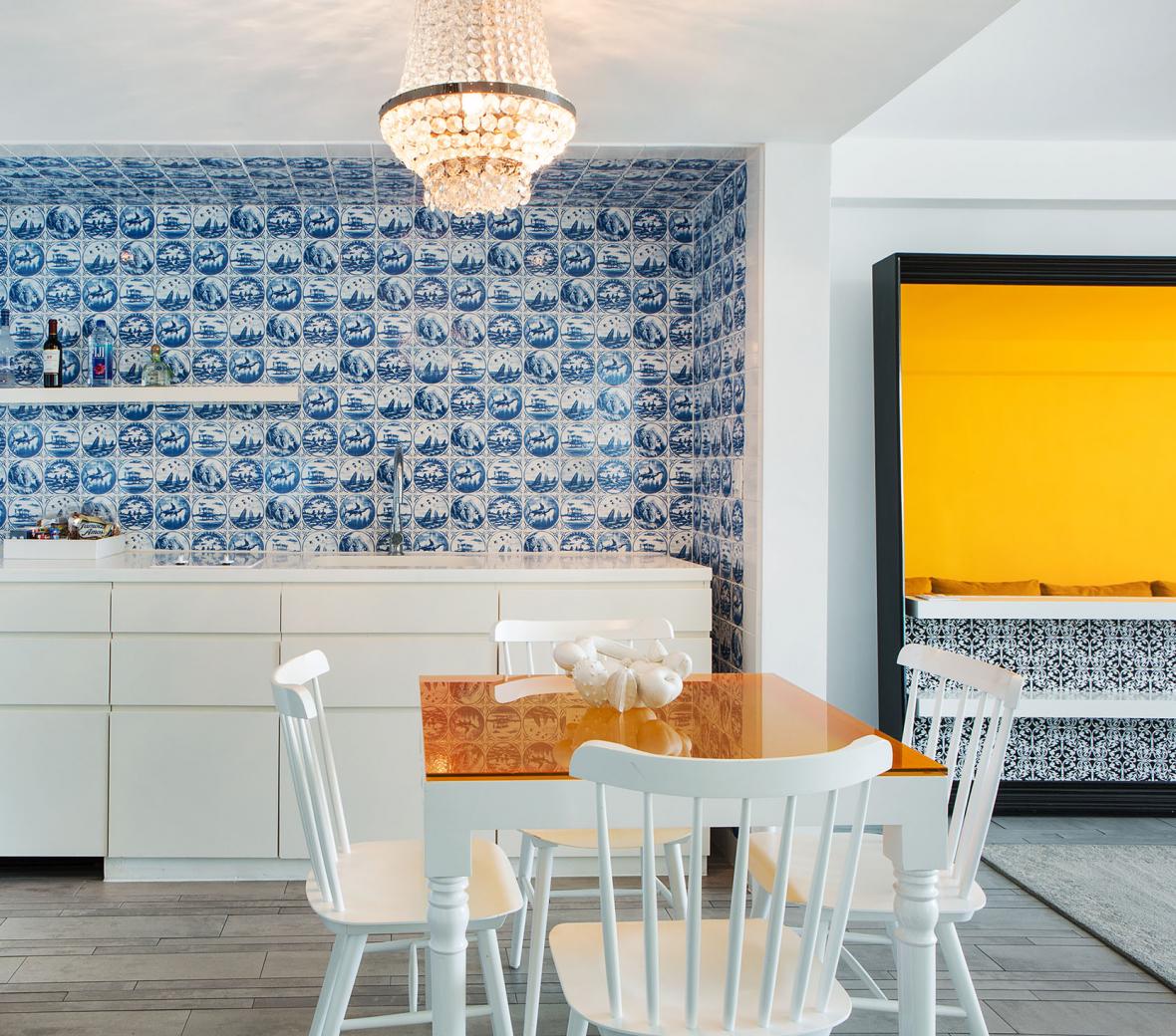 A table with chairs around it in a kitchenette with decorative wallpaper.