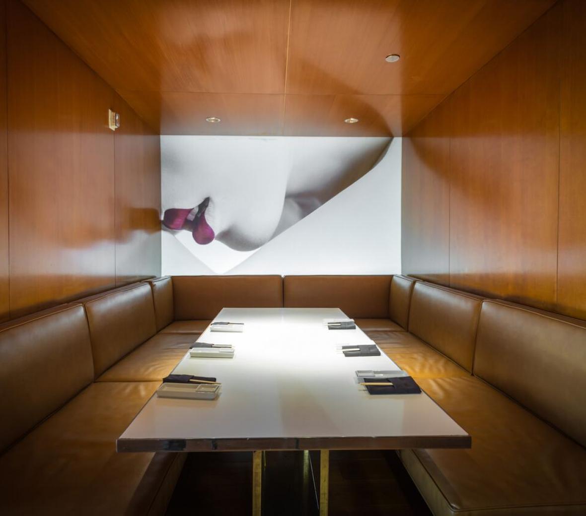 private dining rom with wooden walls, leather booths featuring a mural of red lips