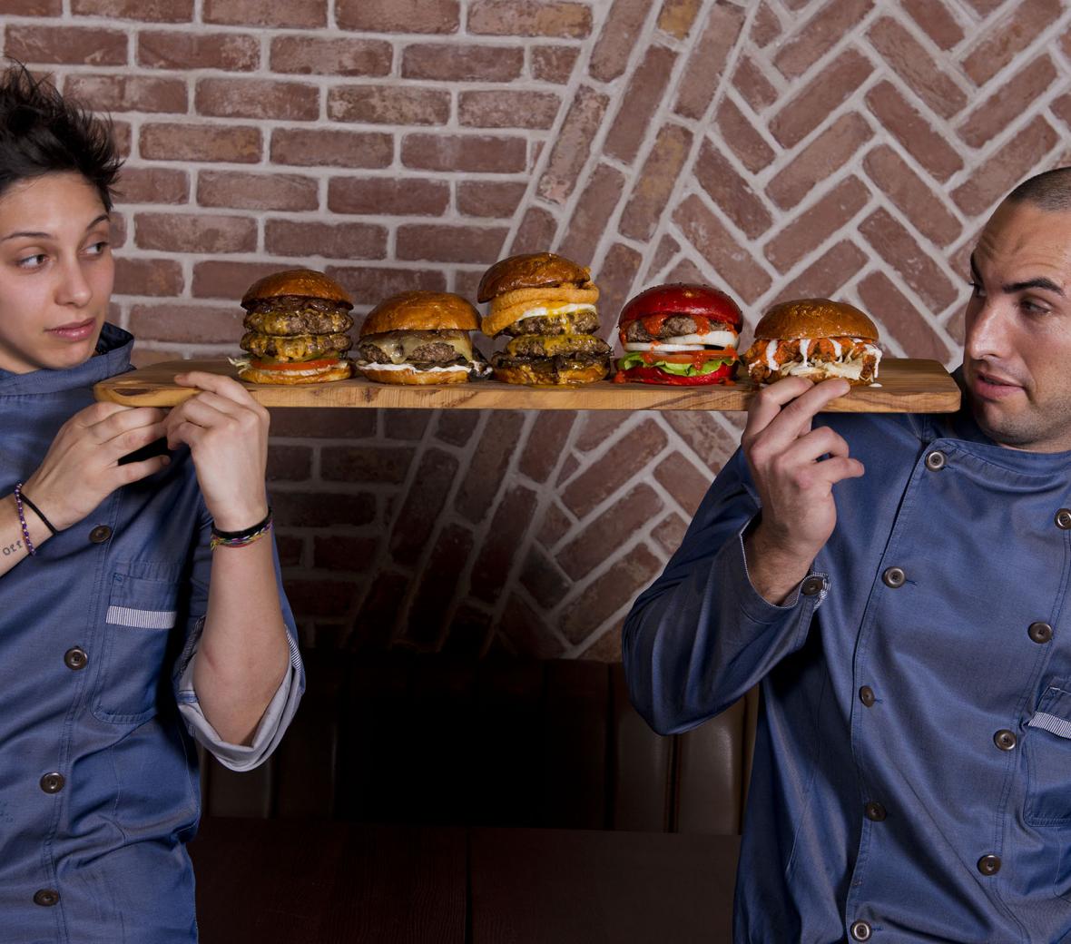 two chefs holding a sampler of burgers