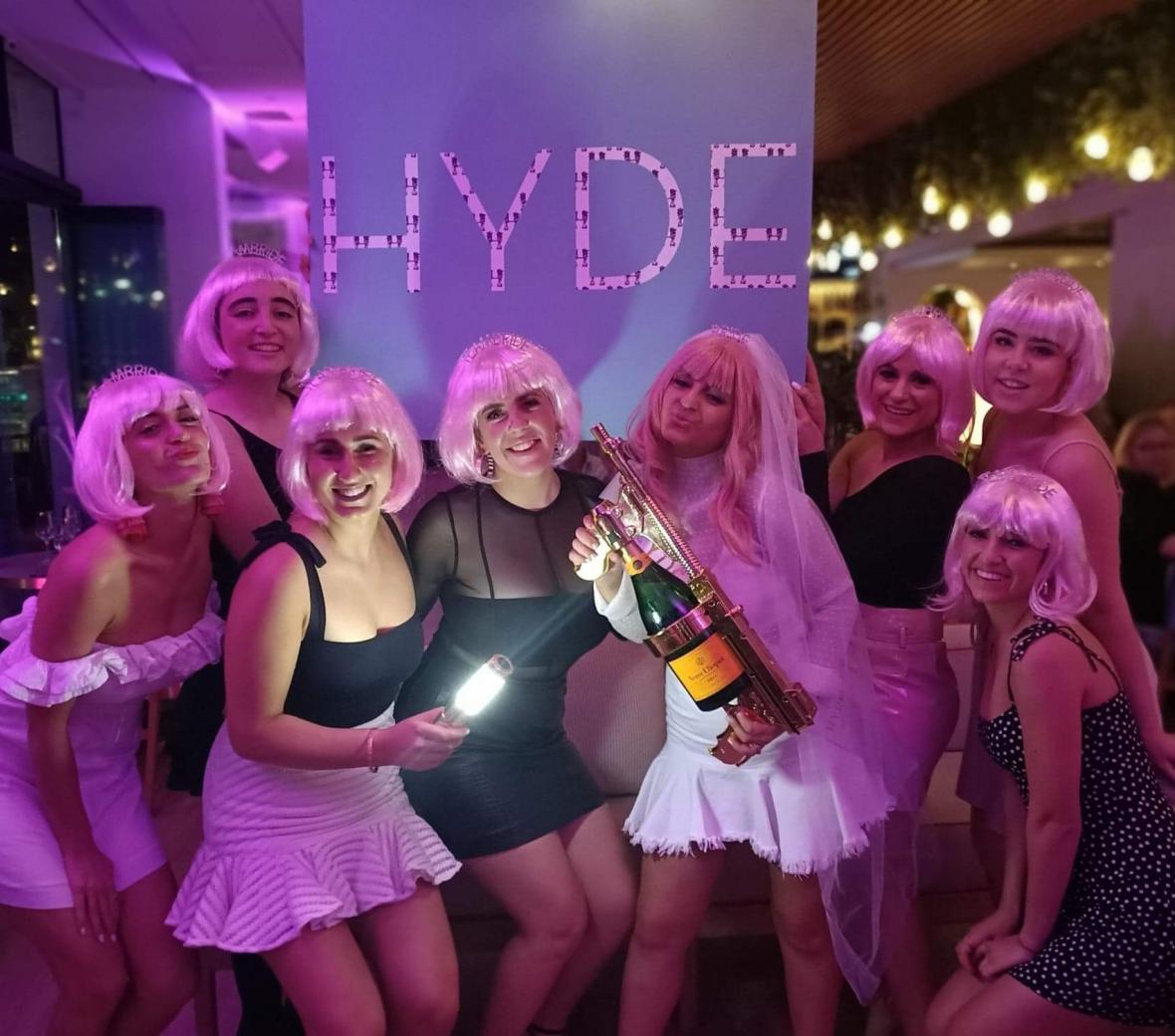 A group of women celebrating a bachelorette standing infront of a HYDE sign.