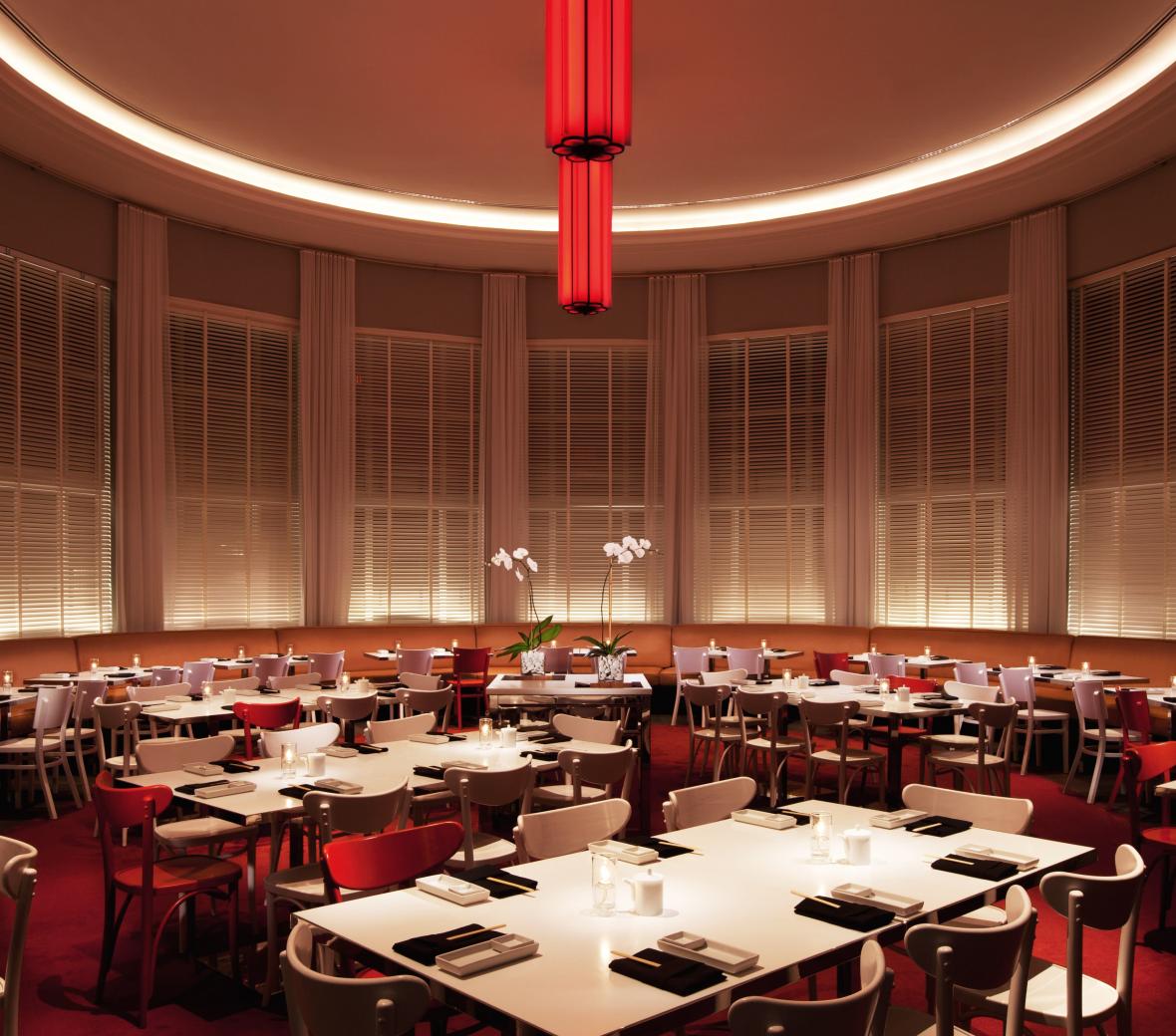 wide event tables in a circular room with red carpet and a red chandelier