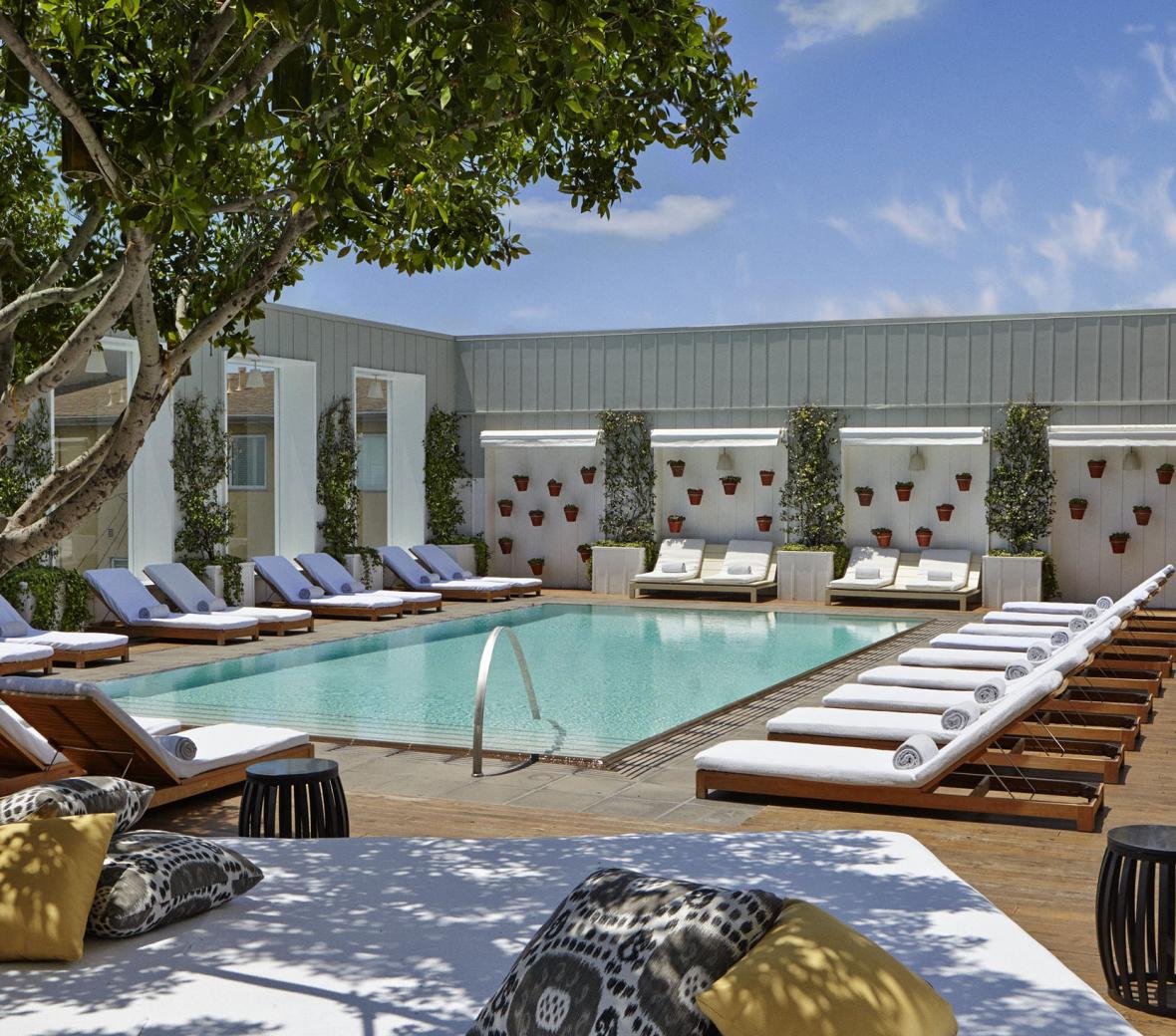 An outside pool with lounge chairs surrounding it.