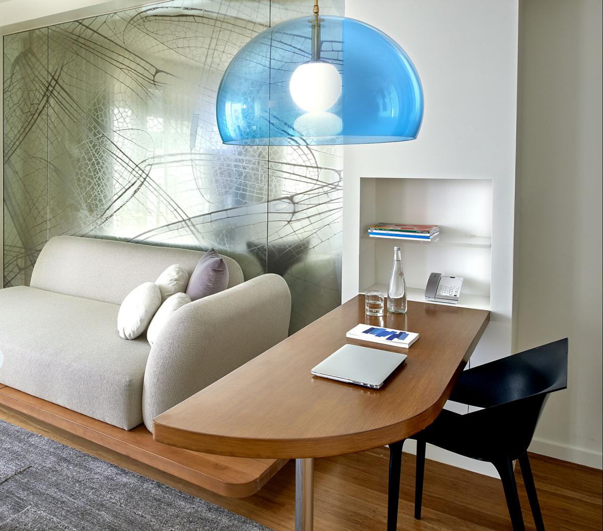 A sofa and desk in a hotel room.