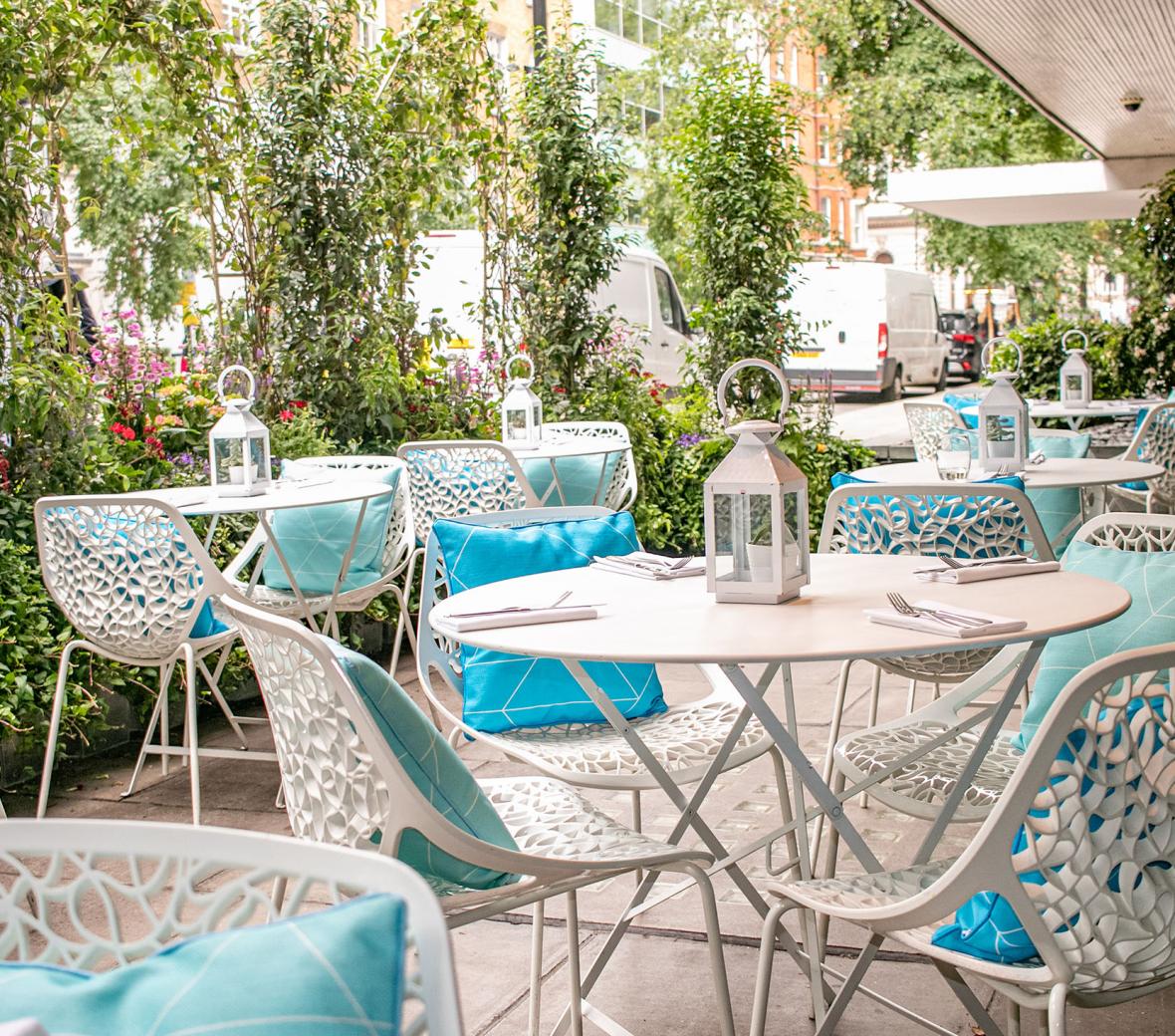 Berners Terrace with white chairs and aqua cushions outside