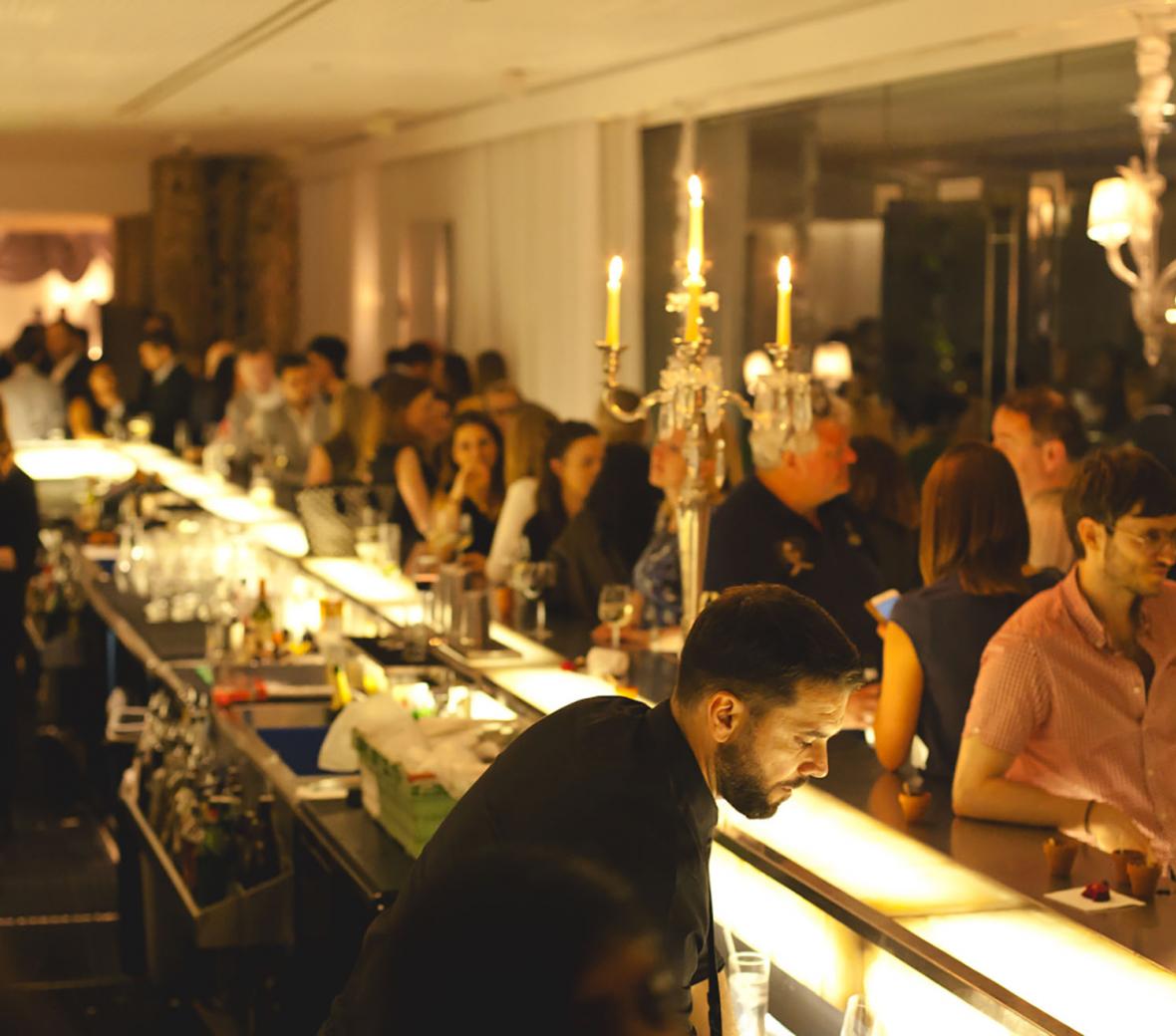 bar packed with people and bartenders