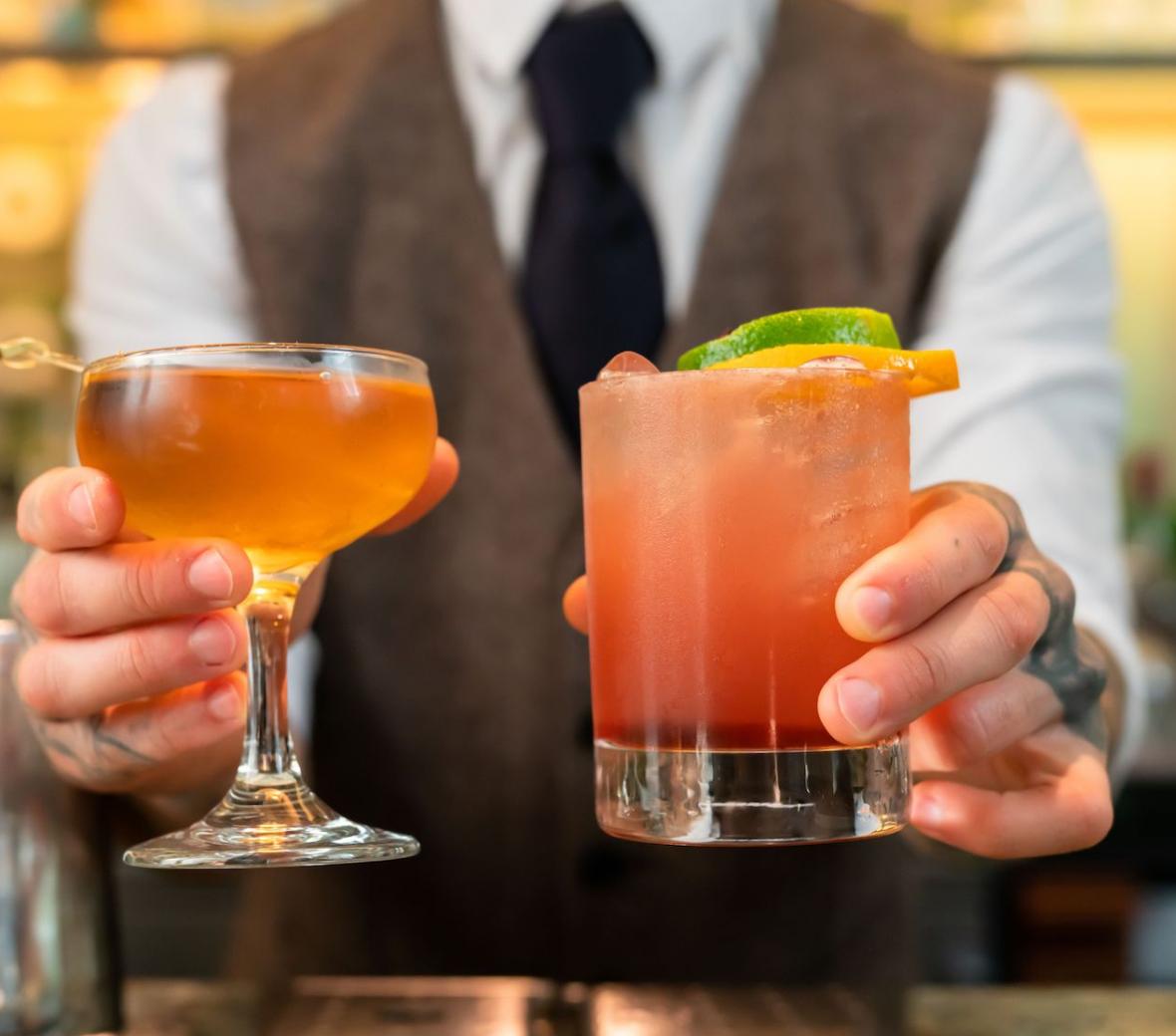 bartender passing out two cocktails