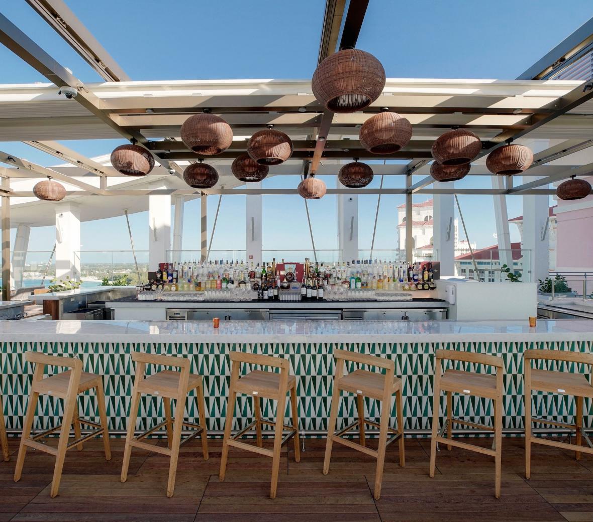 tropical outdoor rooftop bar with bar stools