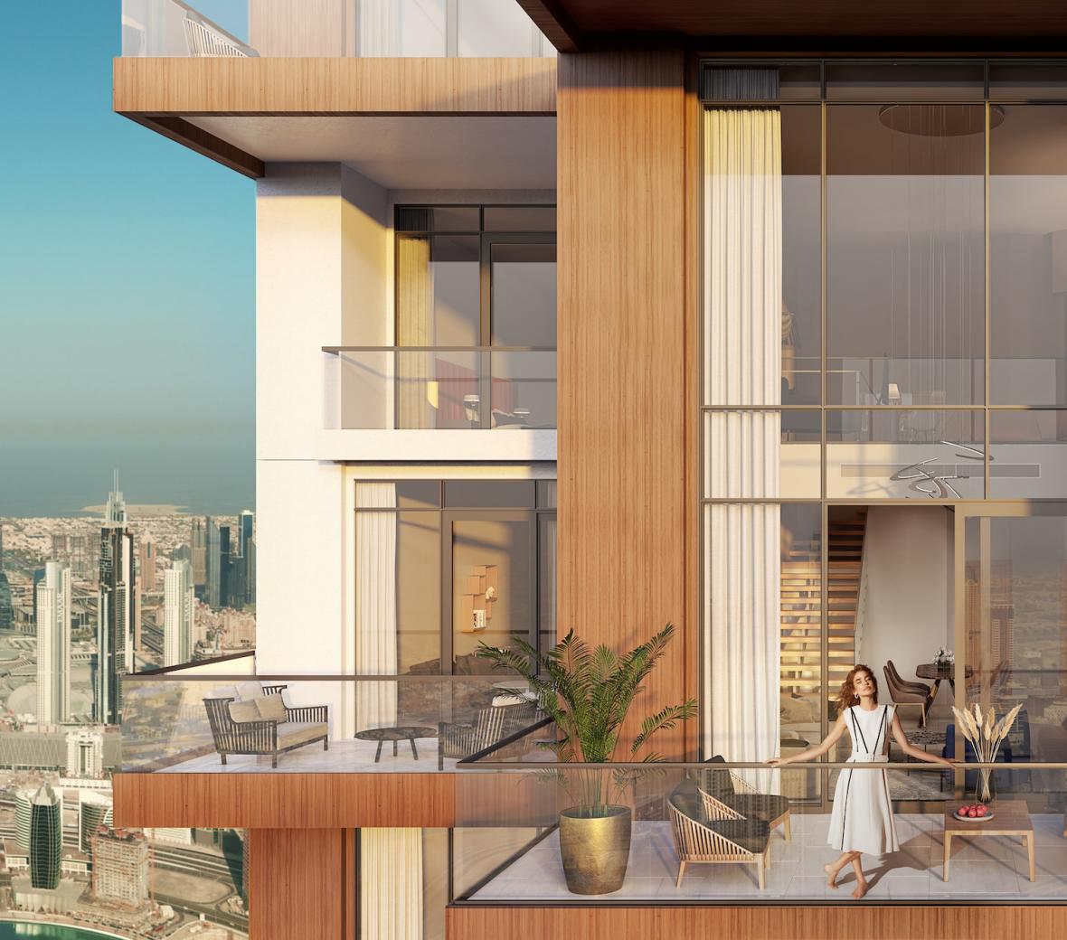 Woman on a patio of a high rise building with Dubai skyline in the background
