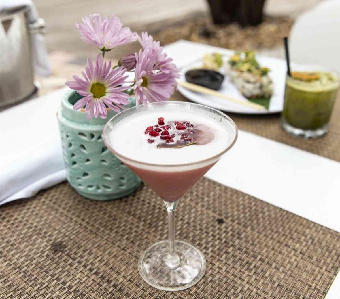 pink cocktail next to flower