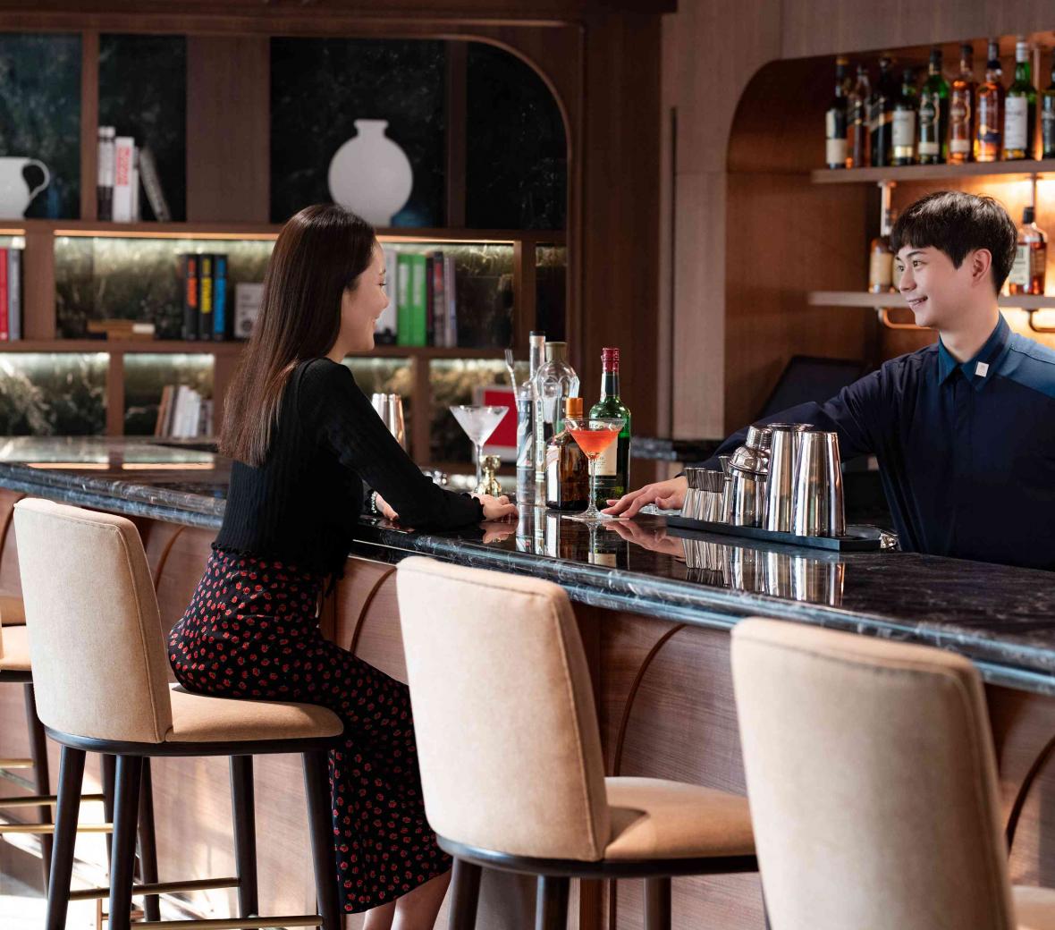 Server handing drink to guest