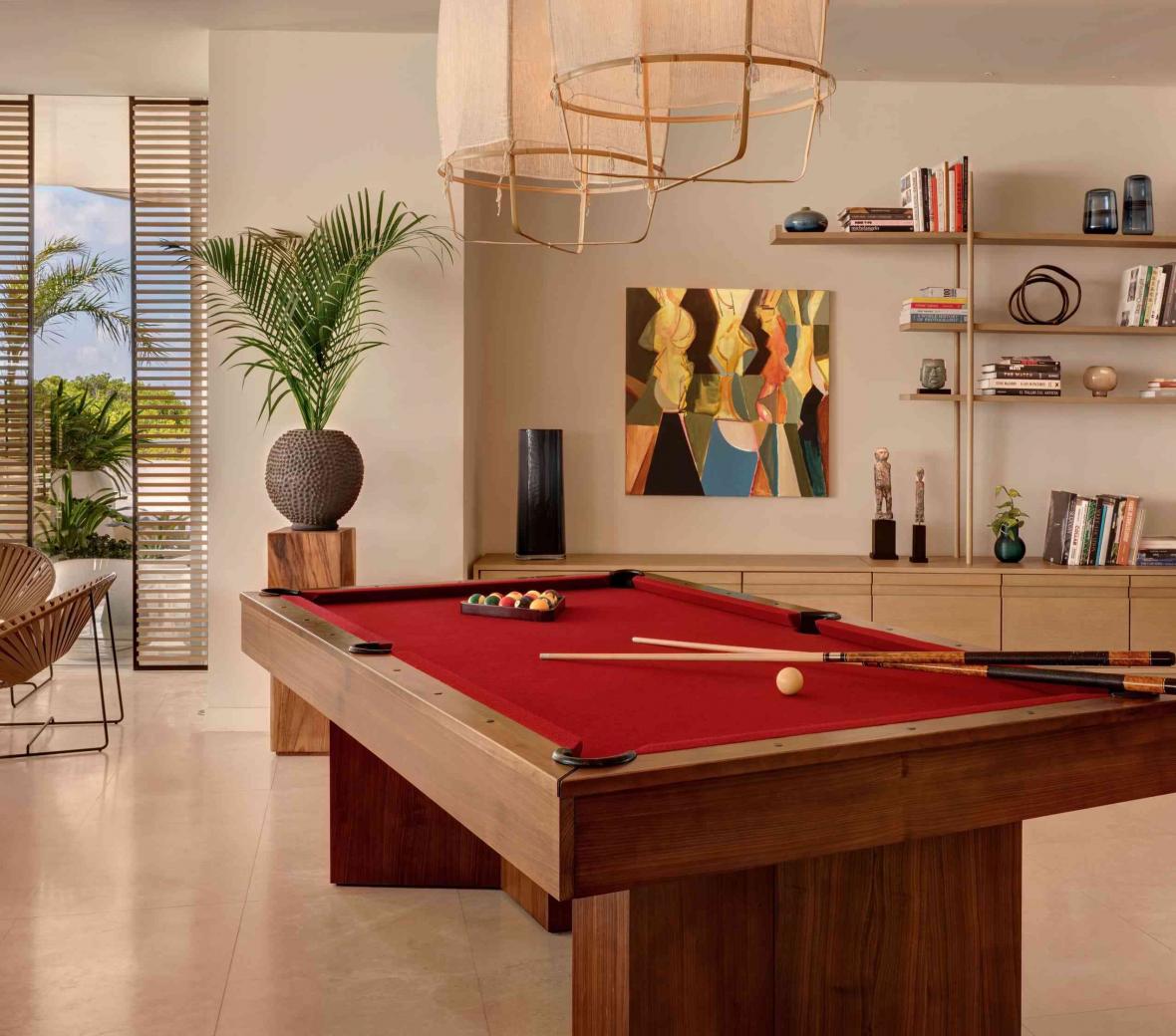 Pool table with seating area to the left and bookshelf to the right