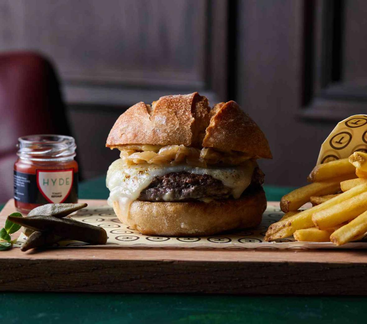 Wooden cutting board with burger and fries