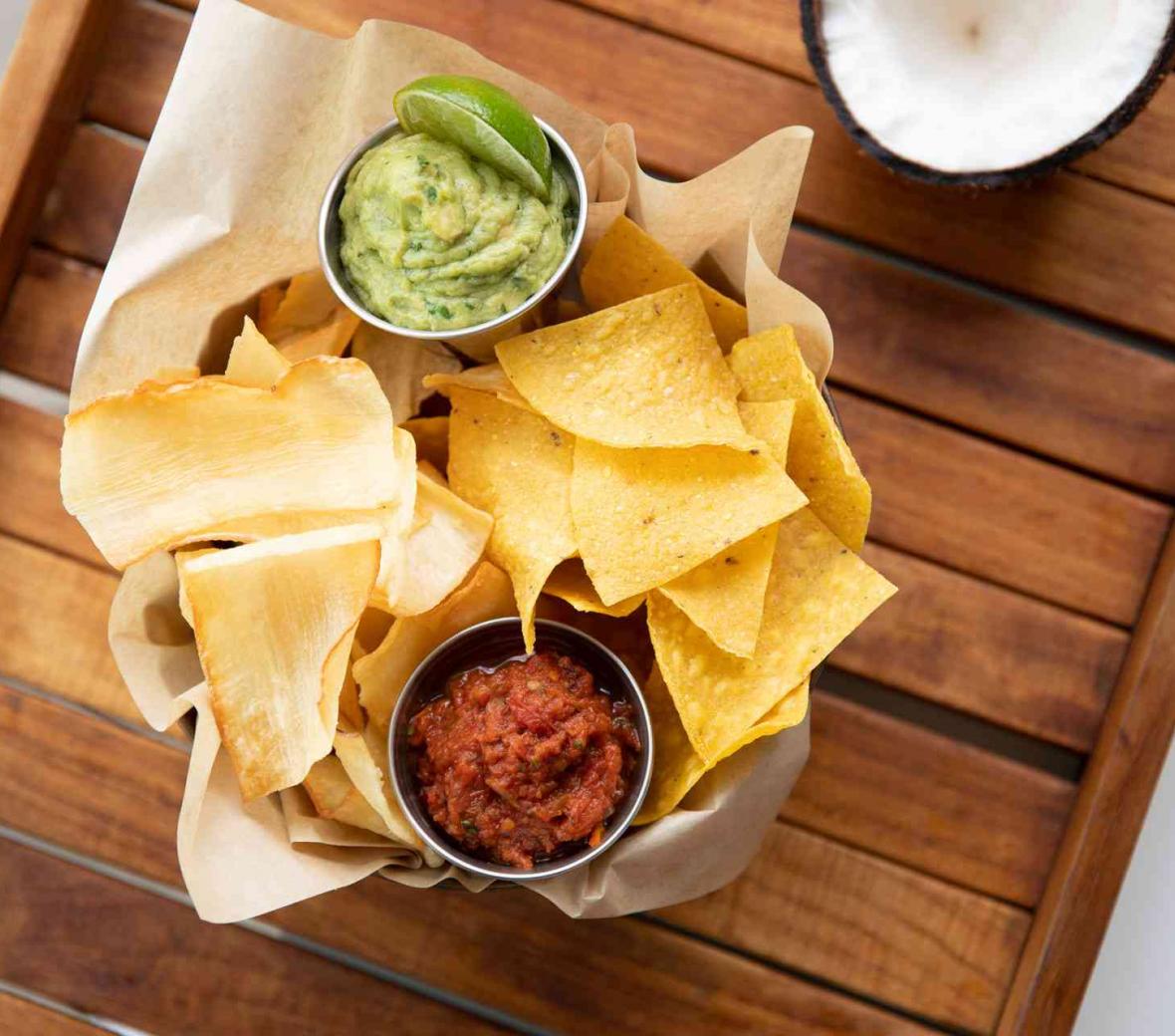 a bowl of corn chips with salsa and guacamole