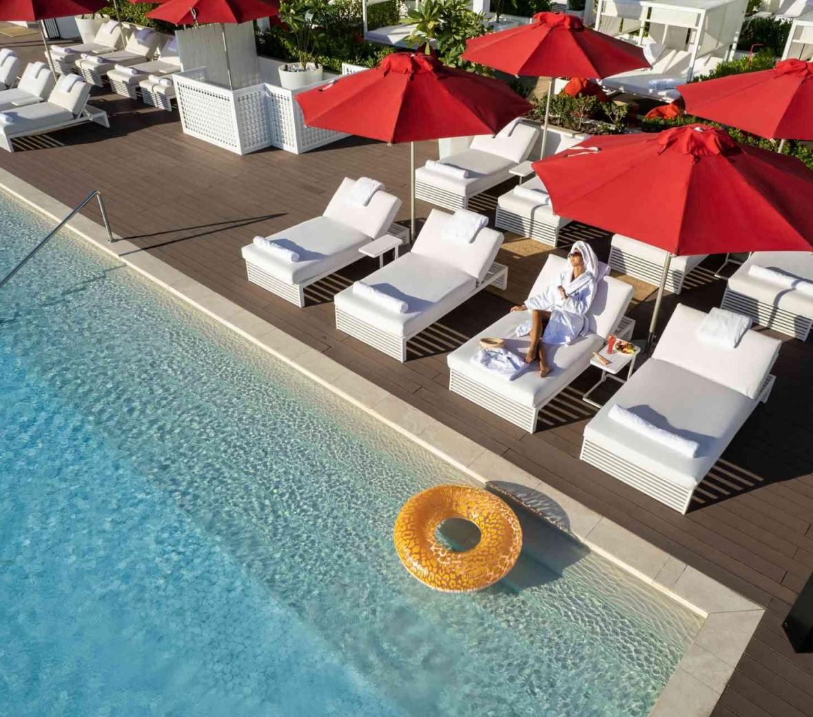 Woman lays out by Th8 Palm Dubai pool