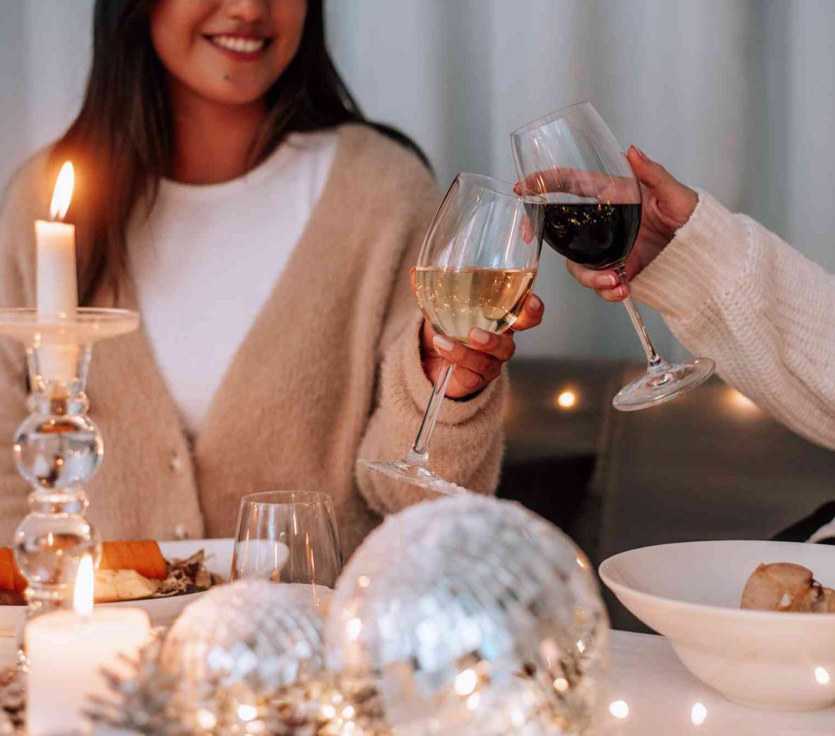 Women clinking glasses of wine over a festive display table
