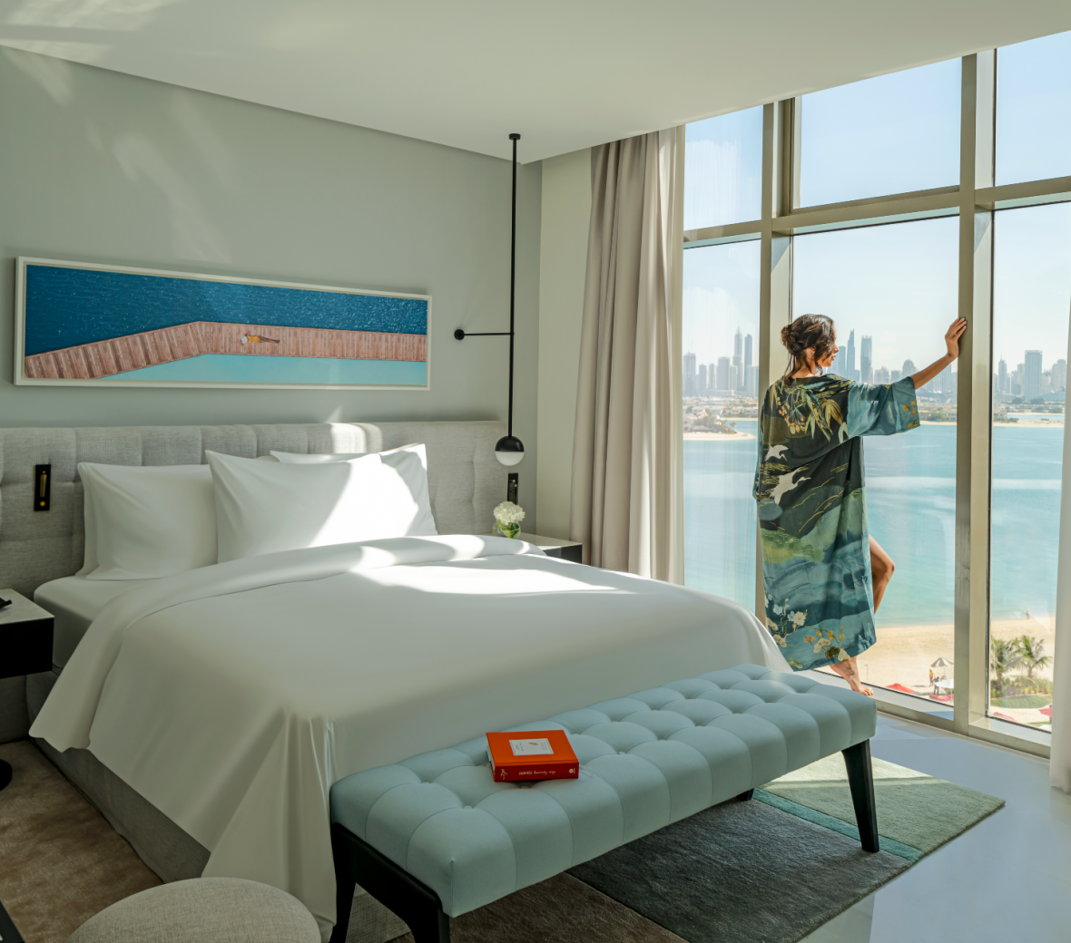Woman stands at window in front of Th8 Dubai