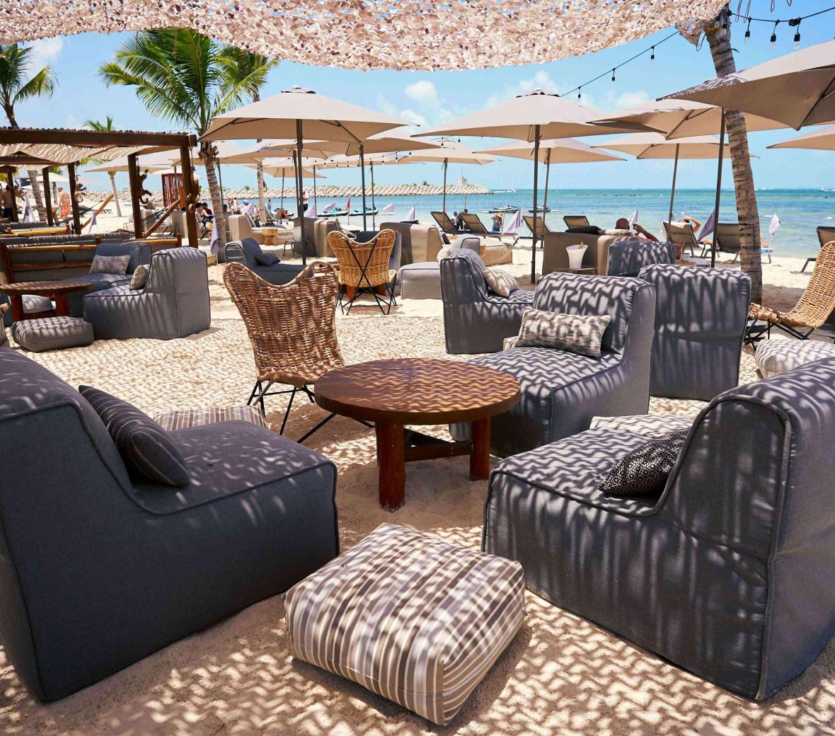 oatio with wicker chairs and tables, by the ocean
