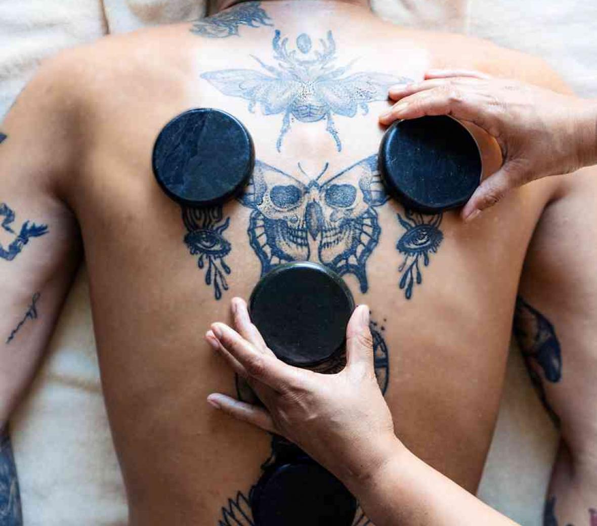 a man doing a hot stone treatment at the spa