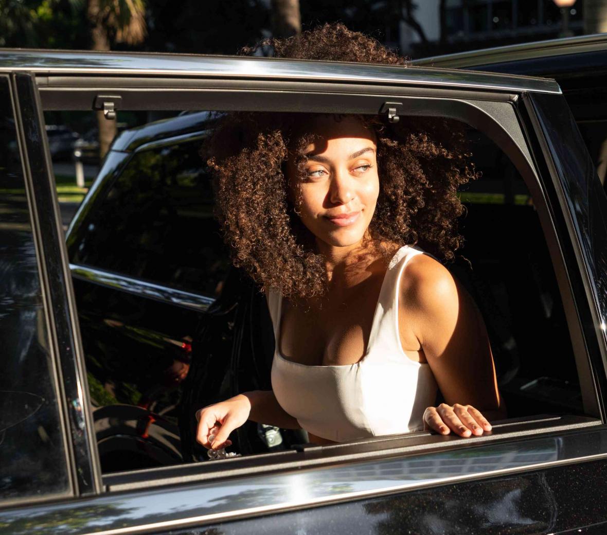 Woman riding in a black Lincoln town car