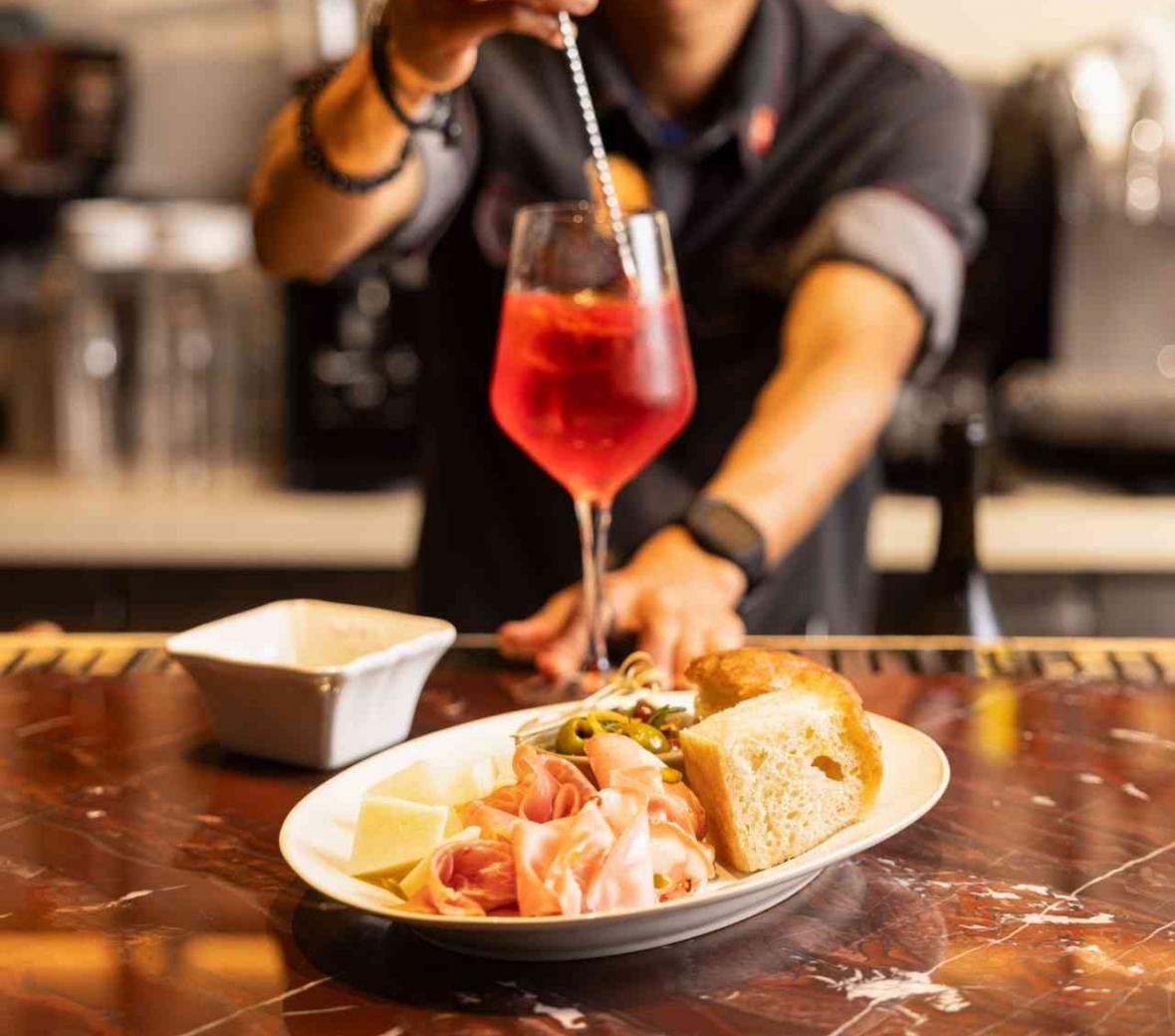 Bartender preparing cocktail during happy hour at Bottega de Carna restaurant