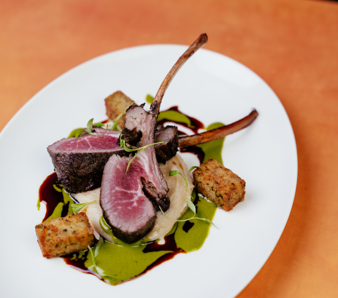 rack of lamb on a mash of potatoes with a green sauce