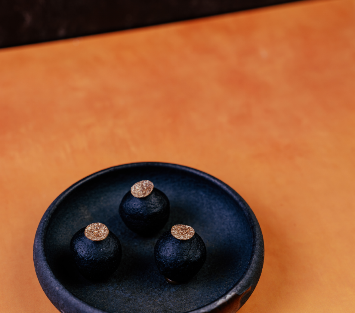 black chocolate truffles in a black round bowl 