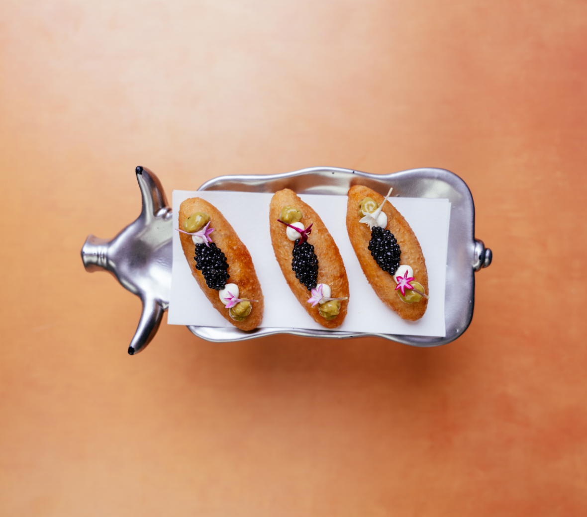 biscuits with caviar on a pig shaped serving dish