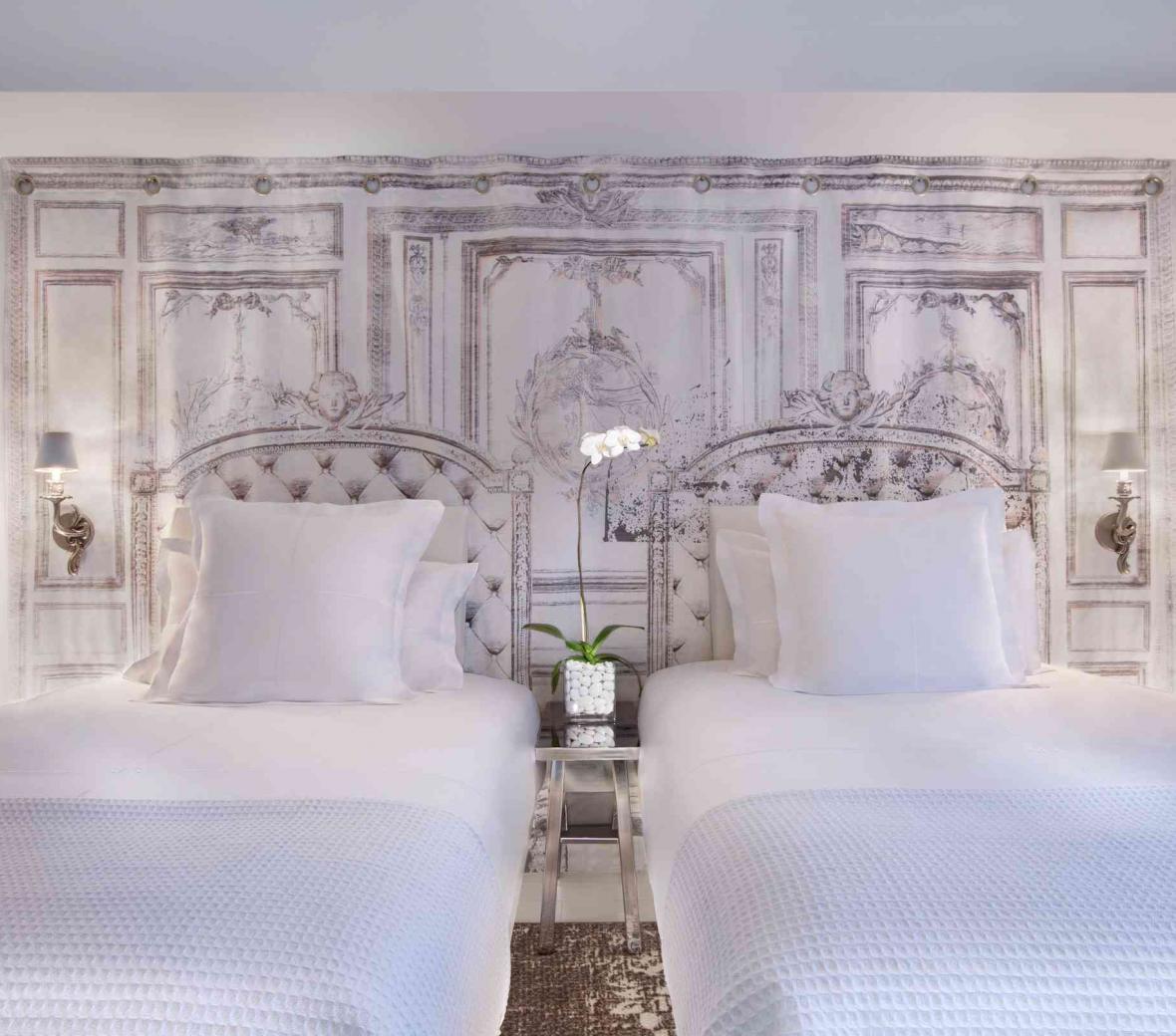 two double beds against a wall with white and black wallpaper design