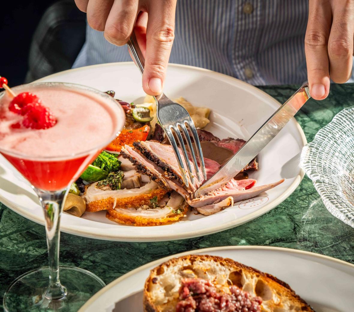 person cutting into a roast beef 