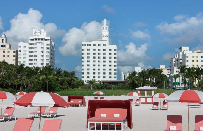 brightly colored beach chairs and umbrellas on a white sand beach
