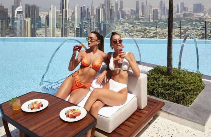 two women eating by the pool