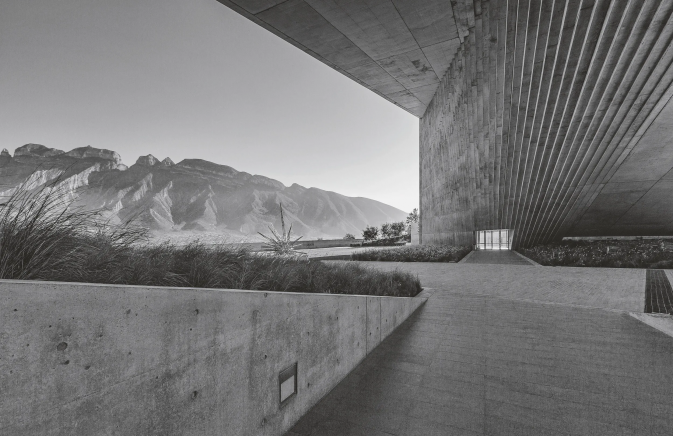 balck and white photo of a landscape with mountains and a building