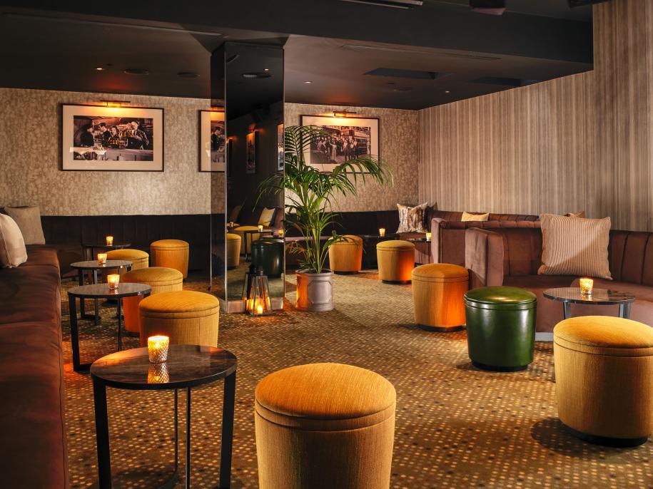 plush stools surround a large projection screen for watching movies