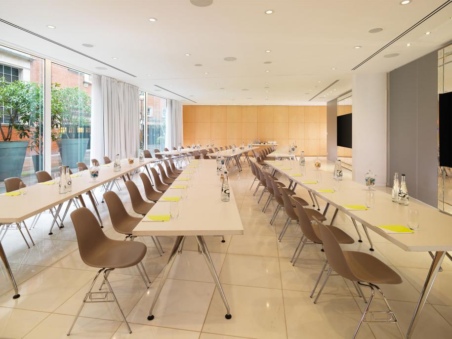 long rows of tables with chairs set up for presentation