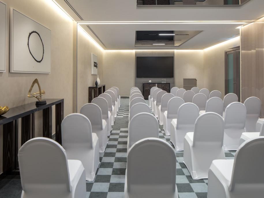 room set up with rows of white chairs