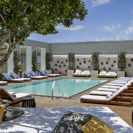 An Outdoor pool surrounded by beech chairs