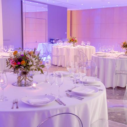 round tables with white lines set for wedding reception