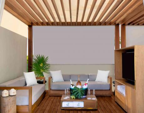 Poolside cabana with two couches, a tv, and some sparkling beverages