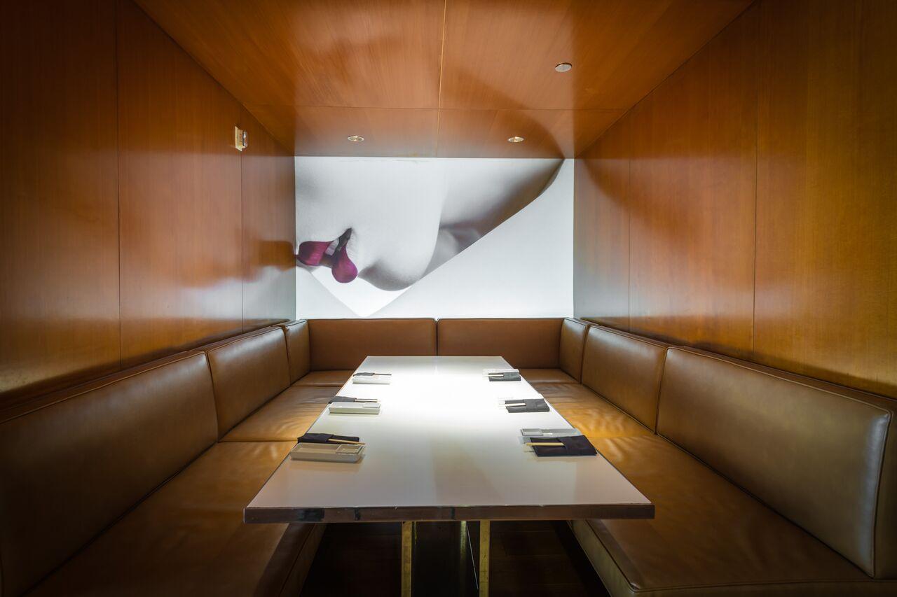 private dining rom with wooden walls, leather booths featuring a mural of red lips