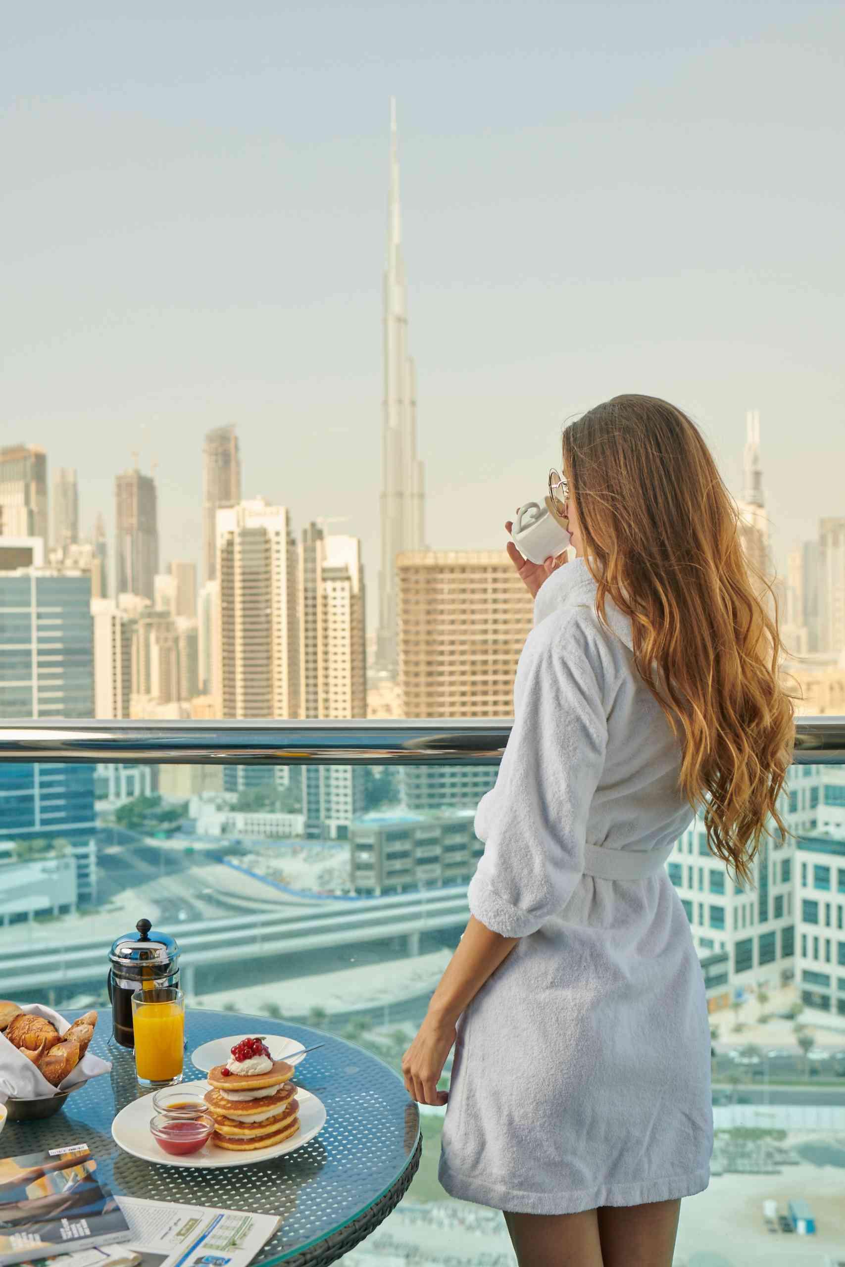 Lady drinking coffee at Hyde hotel room balcony