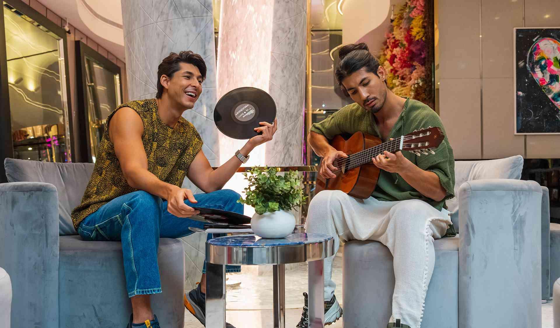two men playing the guitar at the hotel lobby