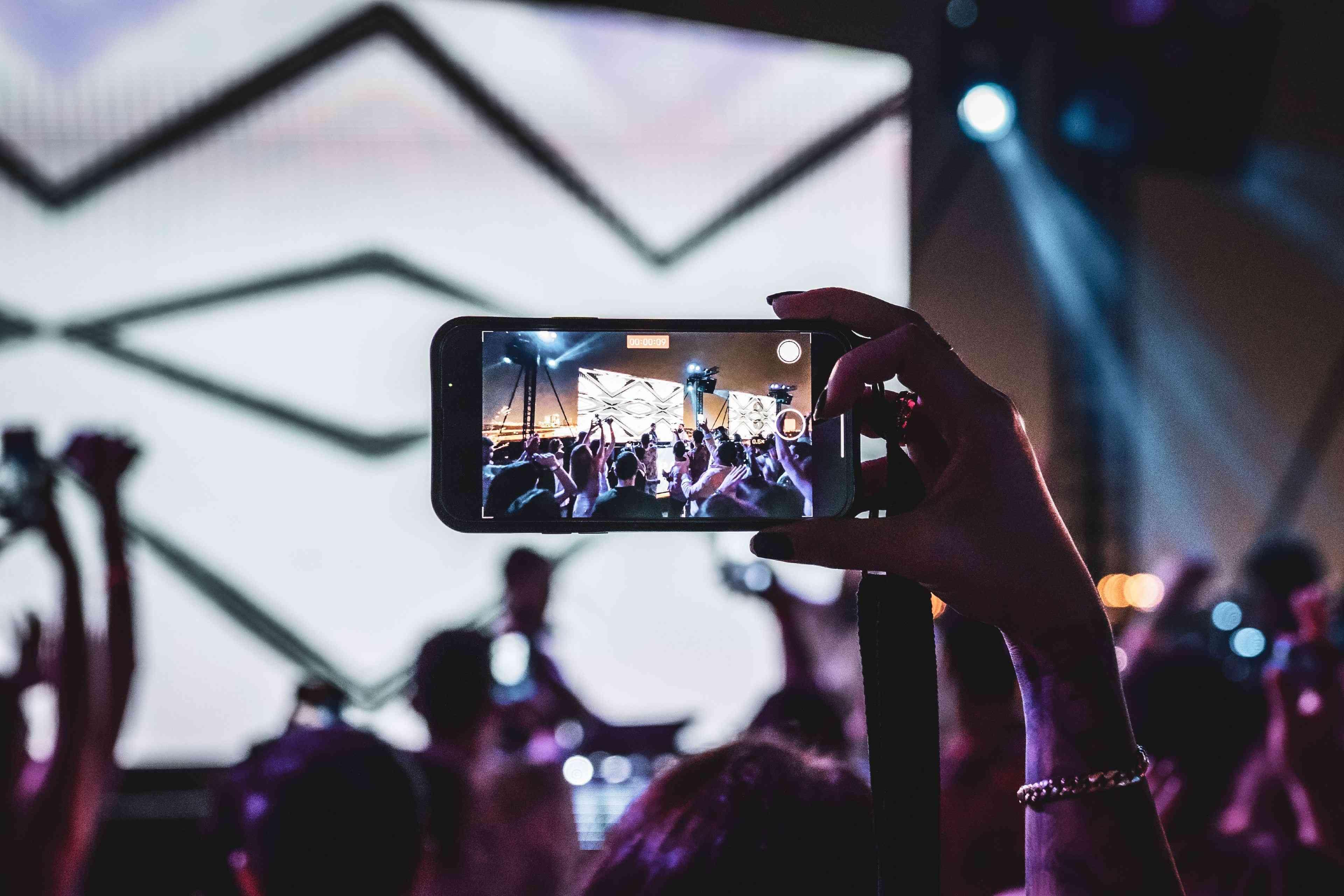 Someone taking a photo of a stage on a cell phone