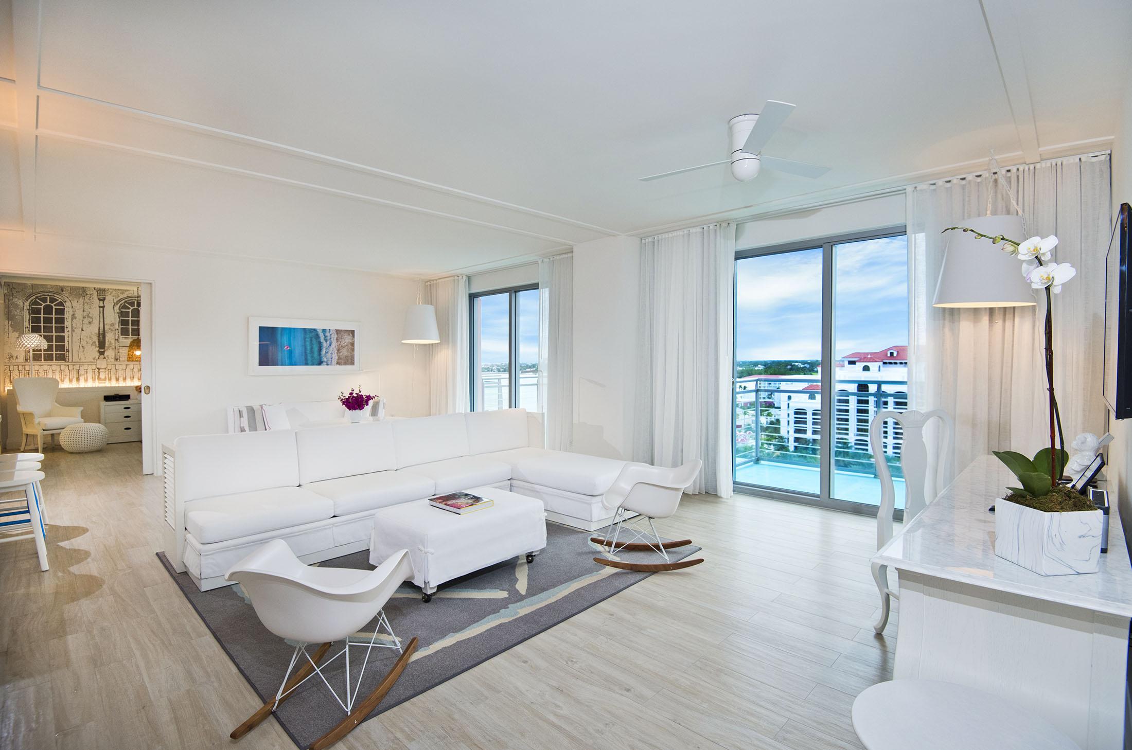 hotel room living space with white couch and chairs