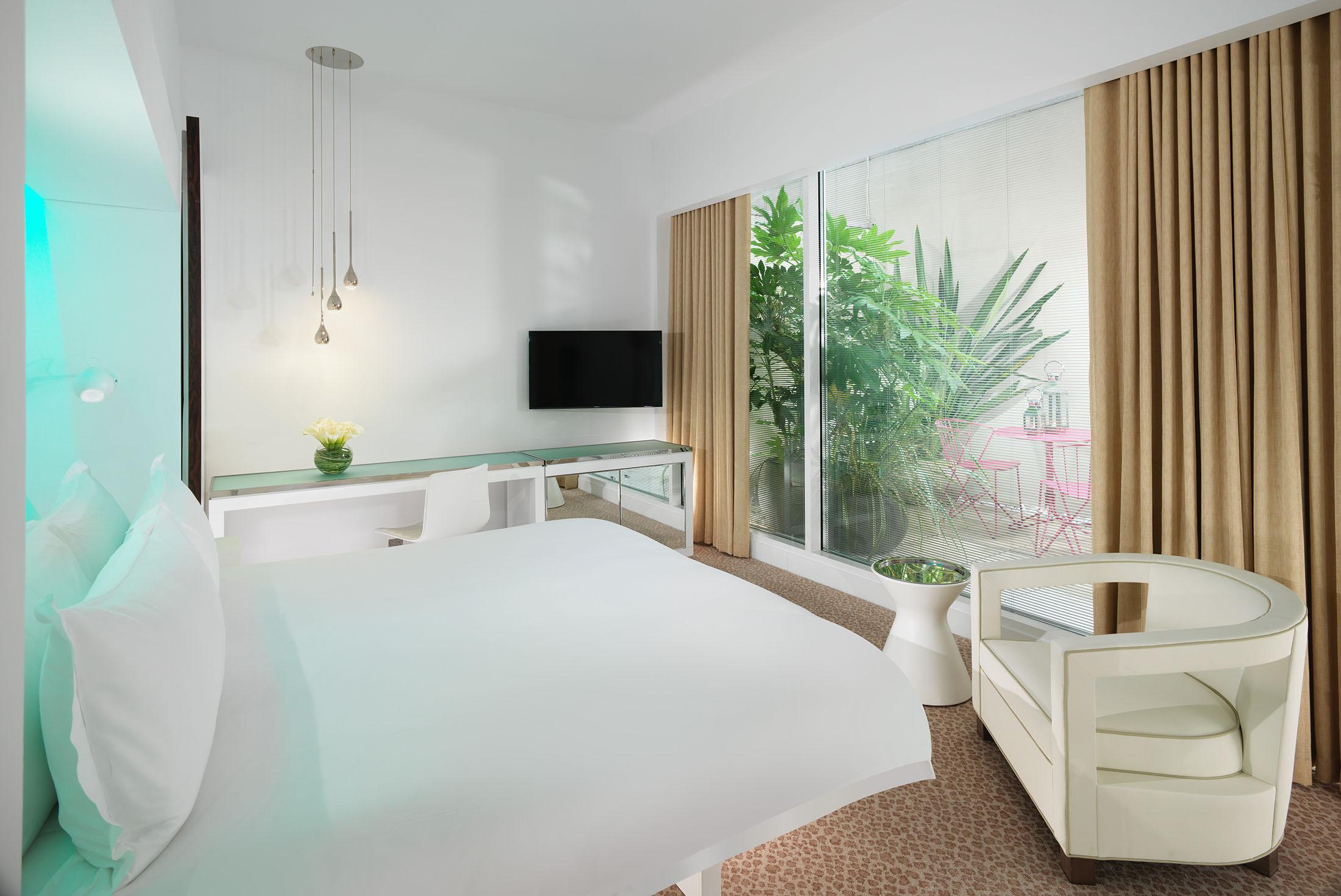 deluxe garden hotel room with bed and plants