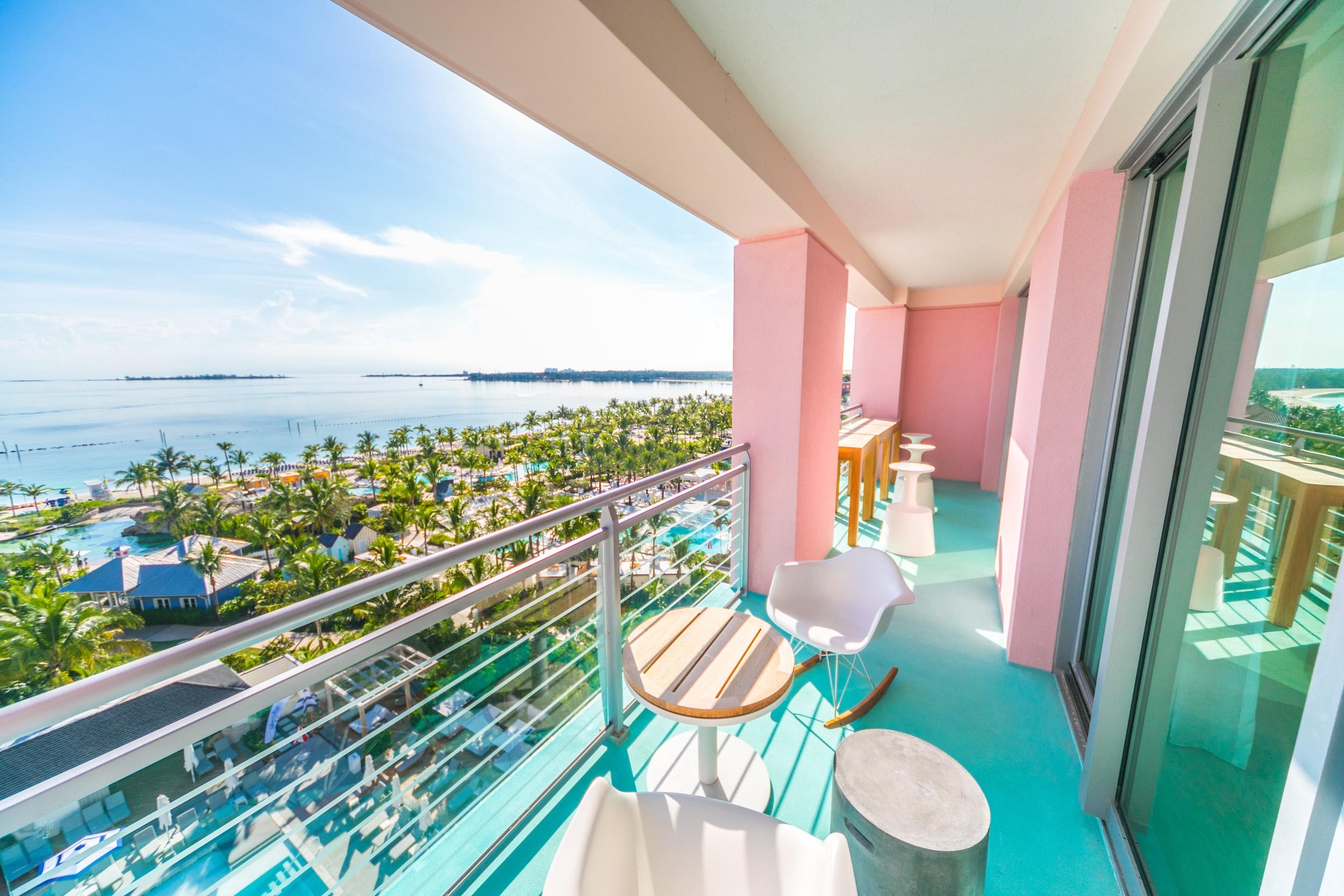Pink and turquoise balcony overlooking tropical ocean