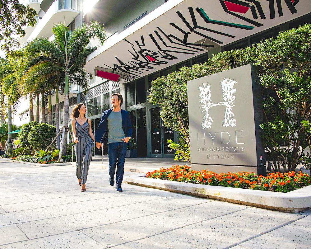 couple walking outside property in sunny weather