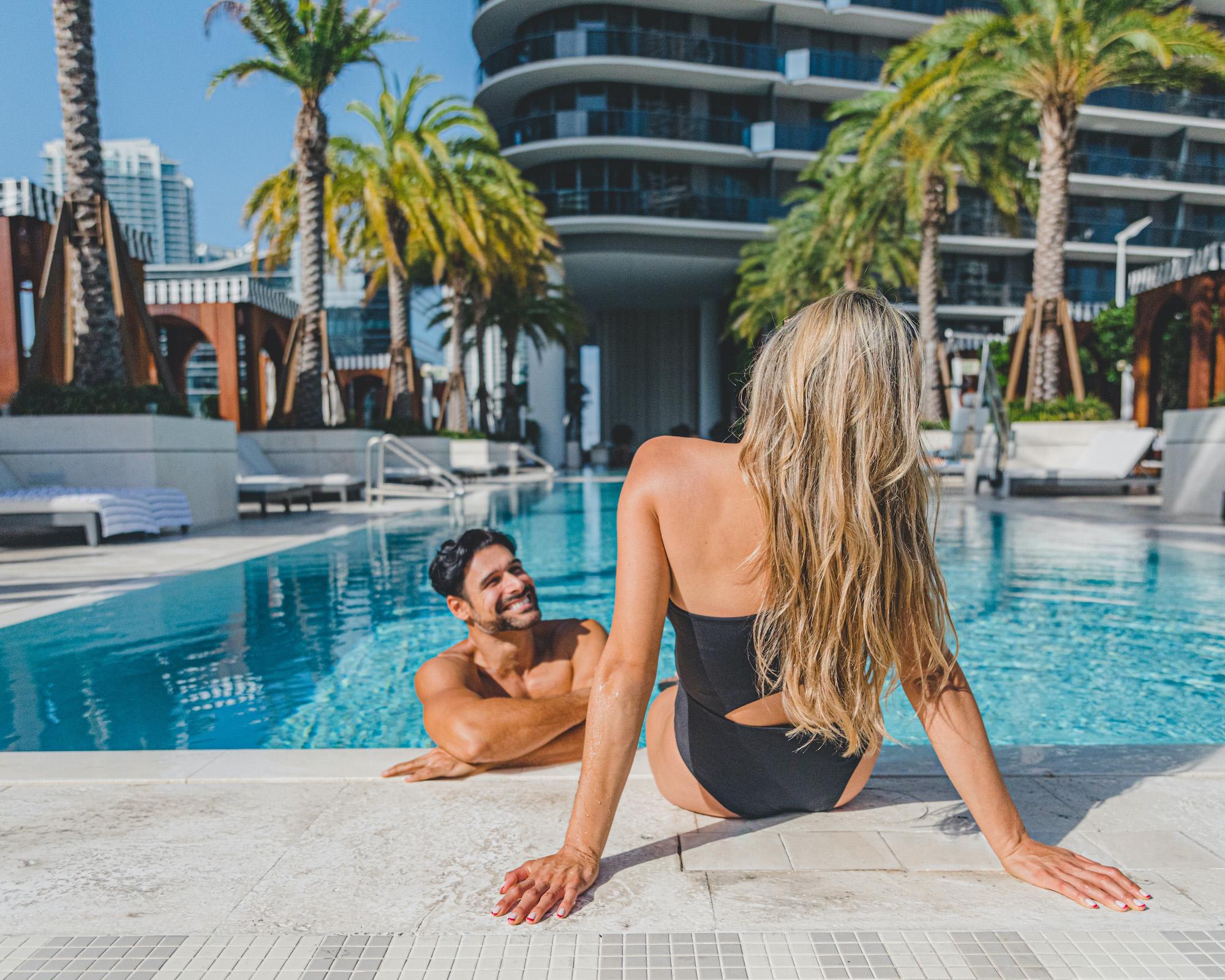 man and woman smiling poolside